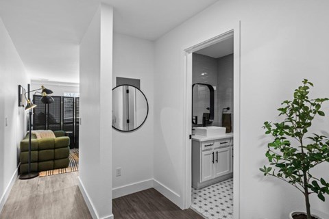 a hallway with a bathroom and a living room